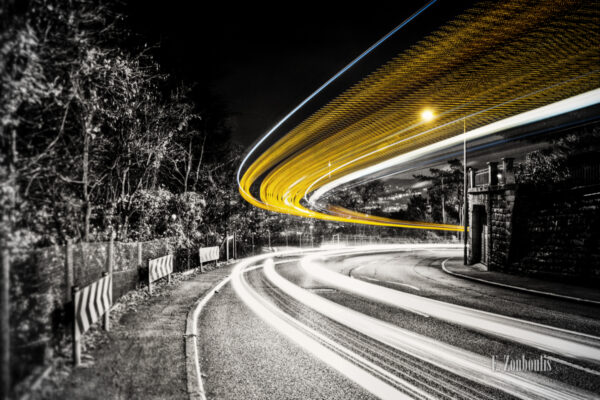 Bild in Schwarzweiss am Killesberg mit gelbem Lichtschweif eines vorbeiziehenden Busses.