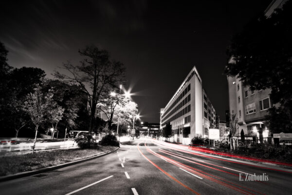 Schwarzweiss-Aufnahme mit roten Lichtschweifen in Richtung der Stuttgarter Innenstadt