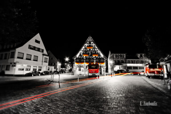 Bild in Schwarzweiss am Rathaus in Stuttgart - Uhlbach. Feurige Elemente in Rot.