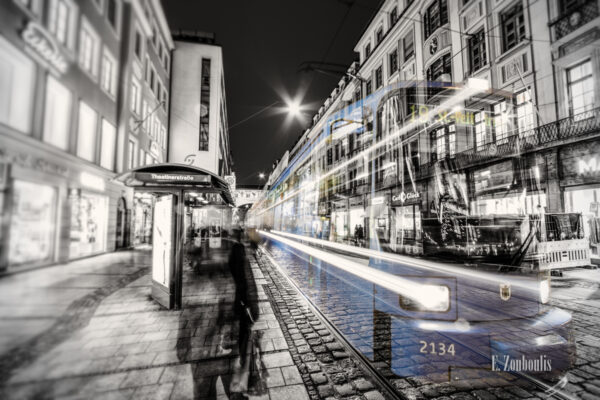 Bild in Schwarzweiss mit blau einfahrender Tram an der Theatinerstraße.