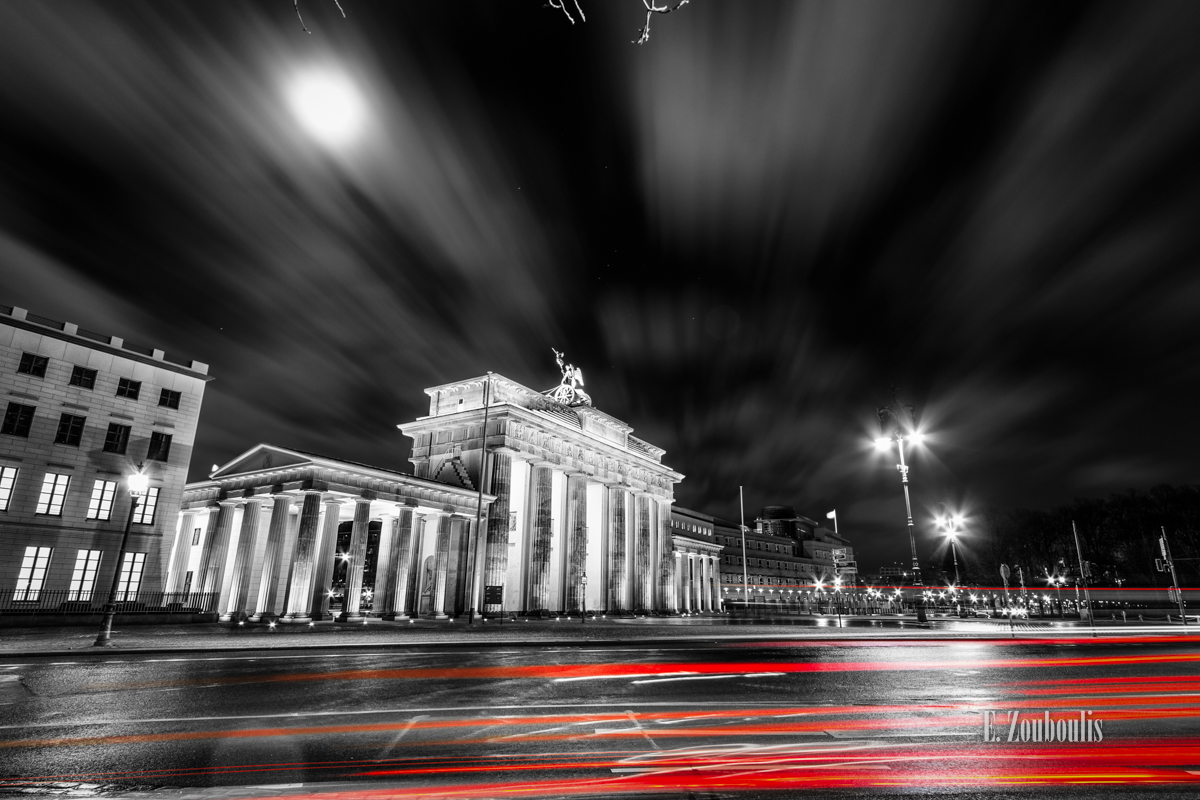 Langzeitbelichtung am Brandenburger Tor in Berlin. Schwarzweiss mit roten Lichtschweifen, die den Verkehr erkennen lassen