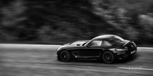 Schwarzweiss-Aufnahme eines vorbeiflitzenden Mercedes Benz SLS AMG Black Series