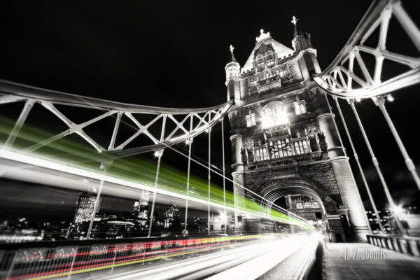 Schwarzweiss-Aufnahme mit farbigen Lichtschweifen, die den Verkehr an der Tower Bridge in London erkennen lassen