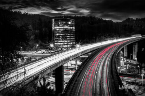 Schwarzweiss-Aufnahme mit roten Lichtschweifen, die den Verkehr kennzeichnen. Nachtaufnahme über der B14