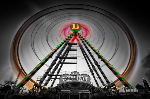 Schwarzweiss-Aufnahme mit farbigem Riesenrad zum Volksfest