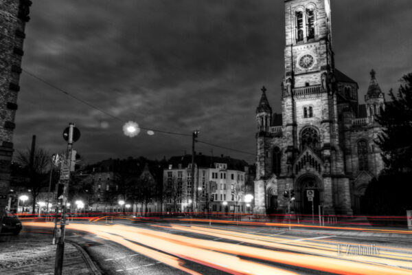 Schwarzweiss-Aufnahme an der Matthäuskirche in Stuttgart Heslach mit farbigen Lichtschweifen, die den Verkehr sichtbar machen