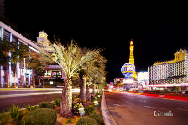 Nachtaufnahme in Las Vegas. Rechts im Bild das Planet Hollywood vor dem Paris Hotel und Casino und auf der linken Seite hinter den Palmen das Bellagio