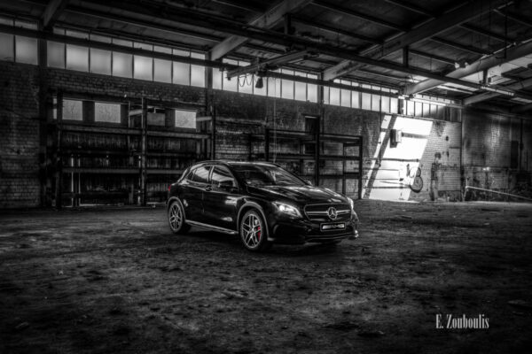 Mercedes Benz GLA 45 AMG in Schwarzweiß mit roten Elementen in einem verlassenen Fabrik Gebäude