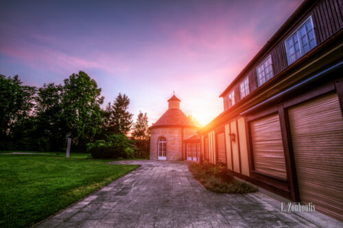 Aufnahme bei Sonnenuntergang an der Villa Schwalbenhof in Gärtringen. Die Sonne geht hinter dem Turmgebäude der Villa langsam unter