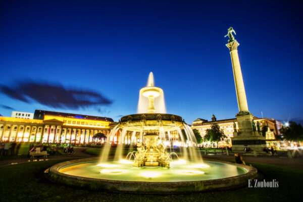 Am Springbrunnen Schlossplatz, Stuttgart zur blauen Stunde. Rechts im Bild die Jubiläumssäule und auf der linken Seite der Königsbau