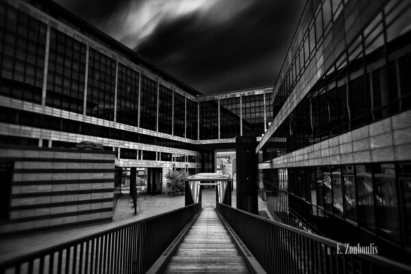 Schwarzweiß-Aufnahme an der LBBW in Stuttgart. Blick die Treppe hinunter und in den Himmel, der durch die lange Belichtungszeit die Wolken wie einen Nebel vorbeizuschicken scheint