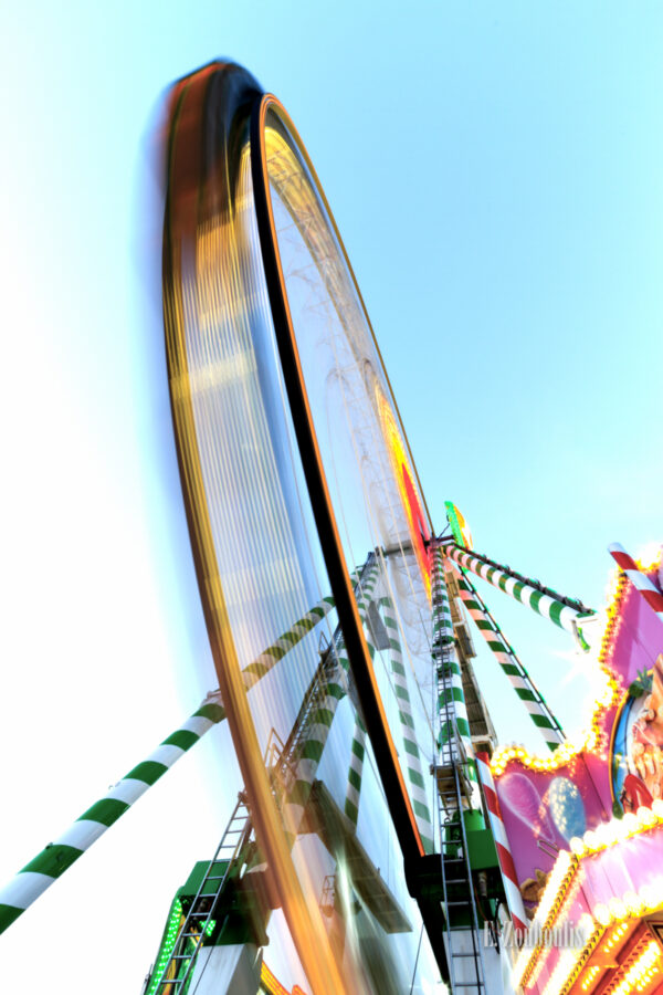 Langzeitbelichtung auf dem Cannstatter Wasen vor einem Riesenrad, dessen Bewegung sichtbar wird