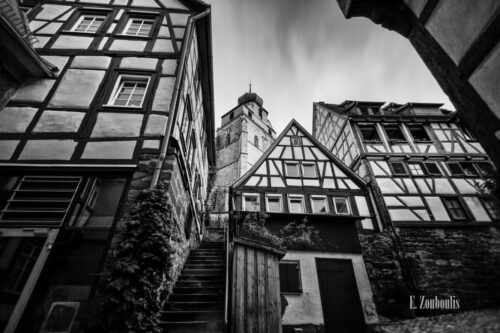 Schwarzweiß-Aufnahme in Herrenberg mit Blick über die alten Fachwerkhäuser auf die Stiftskirche am Schloßberg