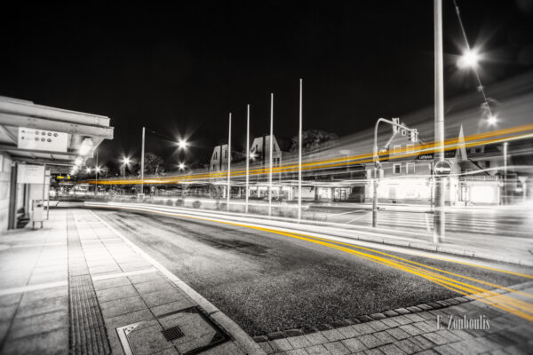 Schwarzweiß Aufnahme in der Löffelstraße am Busbahnhof in Degerloch, Stuttgart. Ein vorbeiziehender Bus ist in der Form eines gelben Lichtschweifs zu sehen