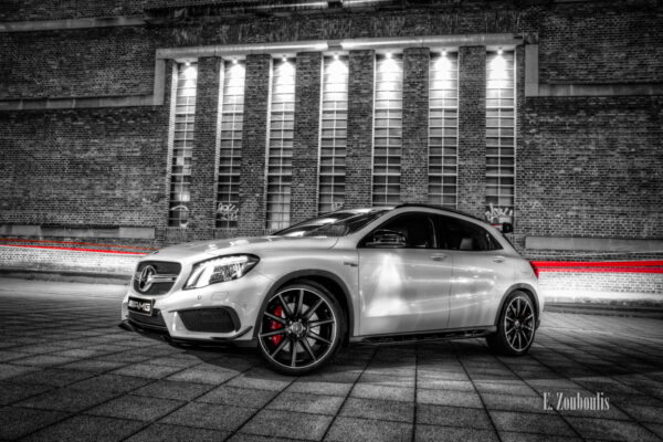 Nachtaufnahme eines Mercedes Benz GLA 45 AMG. Im Hintergrund ein roter Lichtschweif