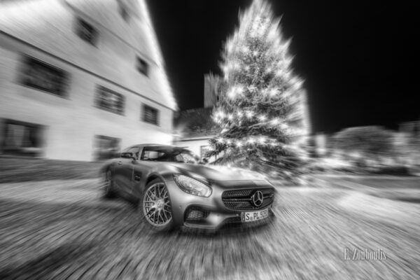 Nachtsaufnahme am Markplatz in Gärtringen mir einem Mercedes Benz AMG GTS vor einem Christbaum. Dynamisches Bild durch einen Zoomburst-Effekt