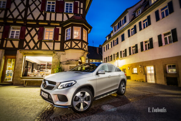 Abendliche Aufnahme zur blauen Stunde eines weißen Mercedes GLE vor den Fachwerkhäusern von Herrenberg. Bild entstanden auf Einladung von Mercedes Benz