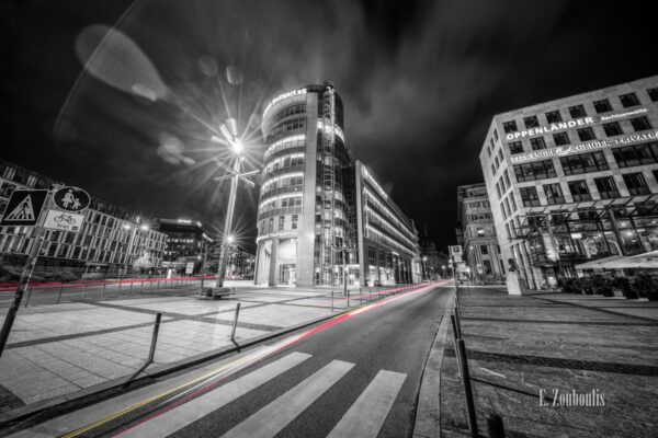 Schwarzweiss Aufnahme am Börsenplatz in Stuttgart bei Nacht. Auf den Straßen sind rote und gelbe Lichtschweife zu sehen, die den Verkehr kennzeichnen.