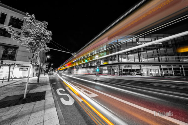 Schwarzweiß Aufnahme bei Nacht in Stuttgart Vaihingen. Der Verkehr ist auf dem Bild durch farbige Lichter und Lichtschweife gekennzeichnet. Im Hintergrund befindet sich das Mercedes Benz Global Training Gebäude