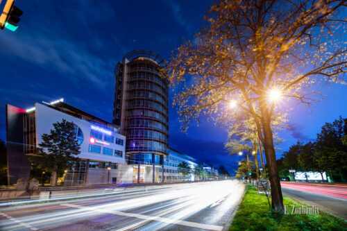 Abendaufnahme zur blauen Stunde am ABB Turm in Stuttgart Degerloch. Im Vordergrund rechts ein Baum und in der Verkehr, der durch die Löffelstraße zieht und einen Lichtschweif hinterlässt