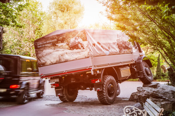 Aufnahme eines Mercedes Unimog U5023, der im Europapark einen Felsen hochfährt. Zur gleichen zeit wird dieser von einem Mercedes AMG G63 überholt. Bild entstanden auf Einladung von Mercedes Benz und dem Europapark