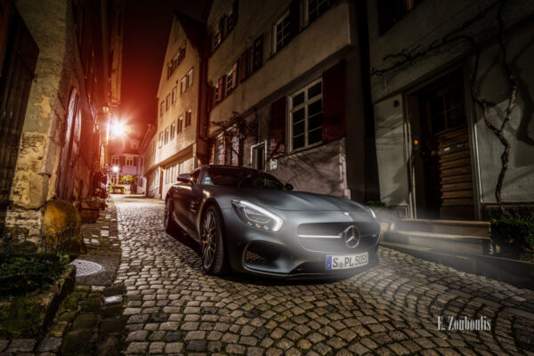 Nachtaufnahme eines Mercedes AMG GTS in der Altstadt von Esslingen. Im Vordergrund der AMG mit leuchtenden Schweinwerfern auf dem Pflasterstein und im Hintergrund die charakteristischen Häuser Esslingens. Bild entstanden auf Einladung von Mercedes Benz