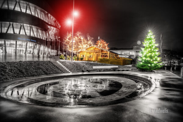 Nachtaufnahme vor der Cannstatter Hütte am Mercedes Benz Museum in Stuttgart. Schwarzweiß mit farbigen weihnachtlichen Elementen