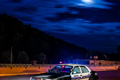 Amerikanisches Polizei Auto im Einsatz. Im Hintergrund sind vorbeiziehende Wolken zu sehen, die durch den Vollmond angeleuchtet werden