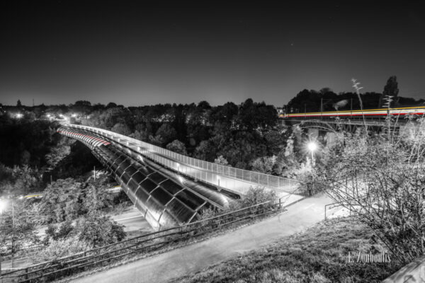 Schwarzweiss-Aufnahme am Österfeld / in Stuttgart Vaihingen. Im Vordergrund ist der Österfeldtunnel mit seiner einzigartigen Architektur zu sehen. Der Verkehr im Tunnel, an der Kaltentaler Abfahrt und rechts im Bild, hinterlässt rote und gelbe Lichtschweife