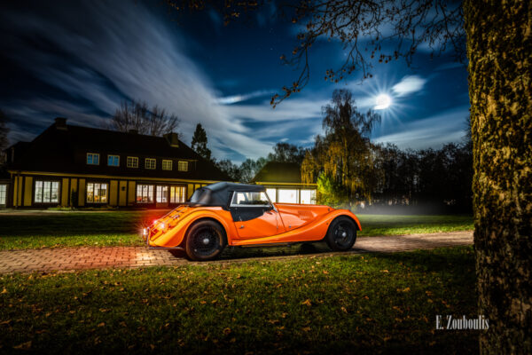 Aufnahme eines orangenen Morgan 4/4 vor der Villa Schwalbenhof in Gärtringen bei Vollmond