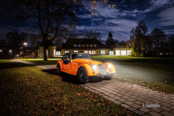 Aufnahme eines orangenen Morgan 4/4 vor der Villa Schwalbenhof in Gärtringen bei Vollmond