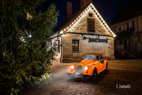 Ein Morgan 4/4 mit seiner einzigartigen “Morgan Orange” – Farbe vor dem Backhaus am Marktplatz in Gärtringen.