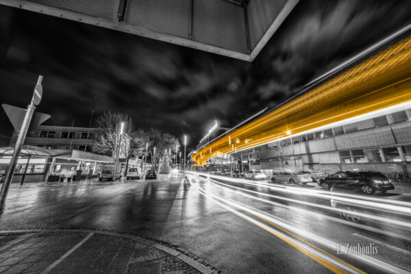 Schwarzweiß-Aufnahme von einem vorbeifahrenden Bus am Bahnhof in Böblingen. Gelbe und rote Lichtschweife kennzeichnen den Verkehr vor dem Mercaden-Einkaufszentrum