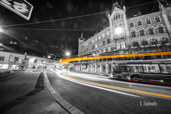 Schwarzweiß-Fotografie am Margaretenplatz in Wien mit gelbem Lichtschweif, der den Verkehr kennzeichnet.