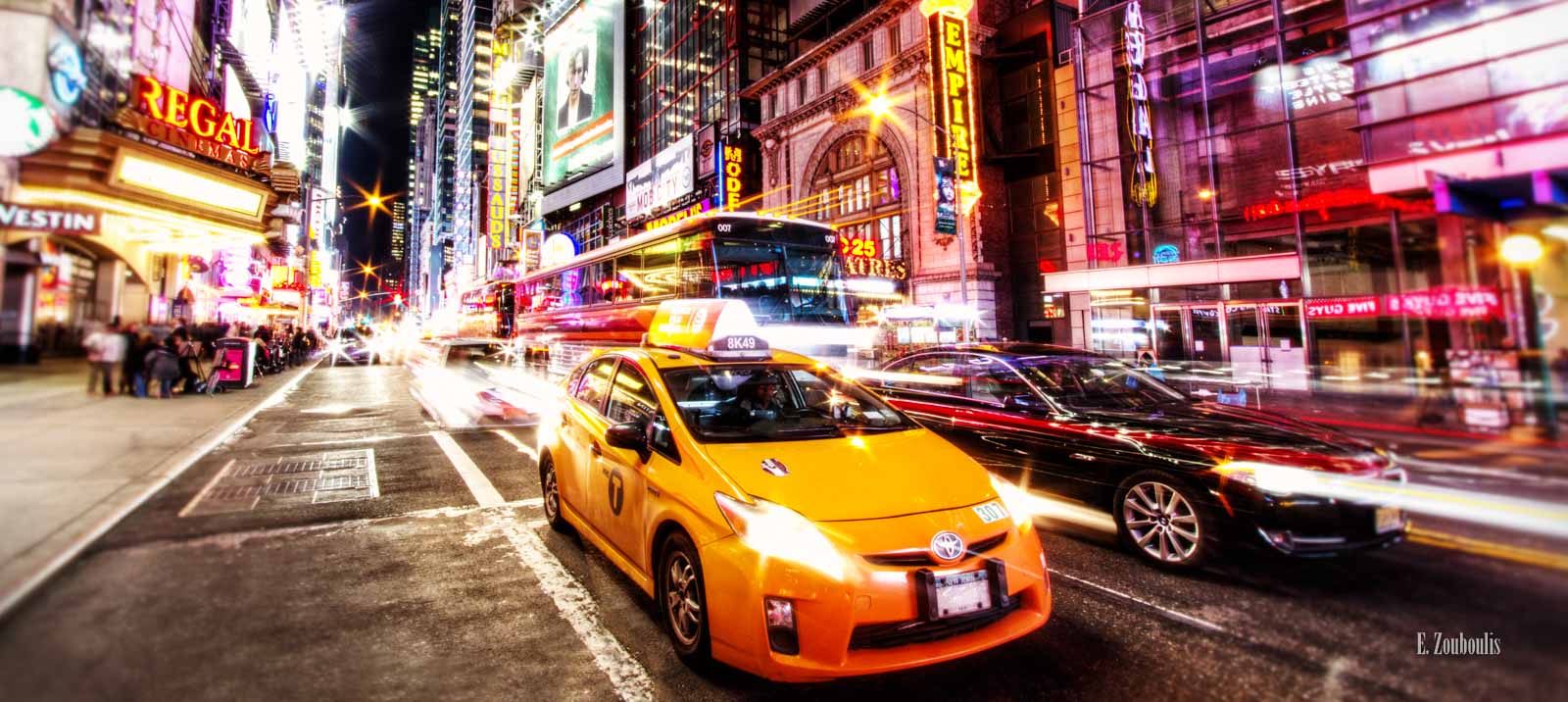 Fahrzeuge, die mitten am Broadway in New York City direkt vor die Kamera fahren, umgeben von funkelnden Lichtern