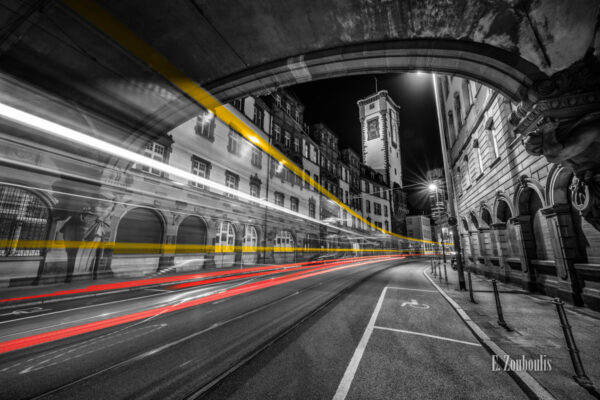 Fotografie an der Bethmannstraße am Römer Frankfurt bei Nacht mit Blick auf den Turm vom Standesamt. Schwarz Weiß Bild mit gelben und roten Light Trails einer vorbeiziehenden Straßenbahn