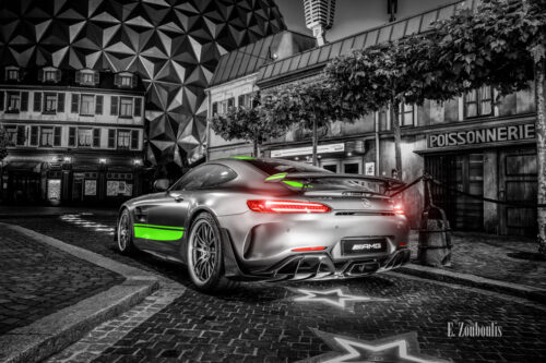Wandbild eines Mercedes Benz AMG GT R Pro im Europa Park. Schwarzweiß mit farbigen Elementen. Im Hintergrund ist der Europa Park zu sehen