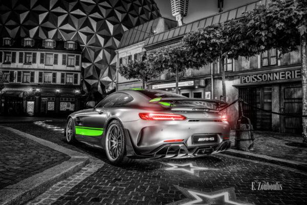 Wandbild eines Mercedes Benz AMG GT R Pro im Europa Park. Schwarzweiß mit farbigen Elementen. Im Hintergrund ist der Europa Park zu sehen