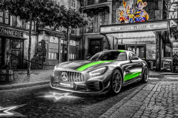 Wandbild eines Mercedes Benz AMG GT R Pro im Europa Park. Schwarzweiß mit farbigen Elementen. Im Hintergrund ist das Europa Park Kino und die Euro Maus zu sehen. Ansicht seitlich von vorne