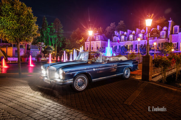 Ein 1971 Mercedes-Benz 280 SE nachts im Europa-Park seitlich von vorne