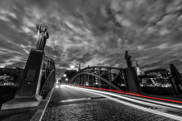 Bild an der Brooksbrücke in Hamburg in der Speicherstadt bei Nacht. Schwarz Weiß Bild mit roten Light Trails des vorbeiziehenden Verkehrs