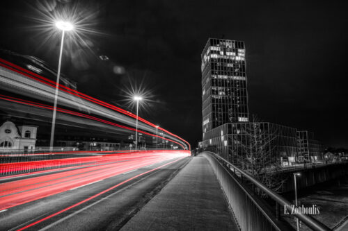 Nachtaufnahme an der Reutestraße in Bonn mit Blick auf das Gebäude der EU Kommission bei Nacht. Zu sehen ist auf der Brücke über dem Bundeskanzlerplatz, wie sich die Light Trails durch die Nacht ziehen