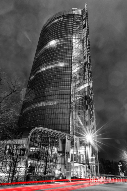 Nachtaufnahme am Post Turm in Bonn im Hochformat mit Blick auf die DHL Hauptzentrale bei Nacht. Zu sehen sind die Light Trails des vorbeiziehenden Verkehrs