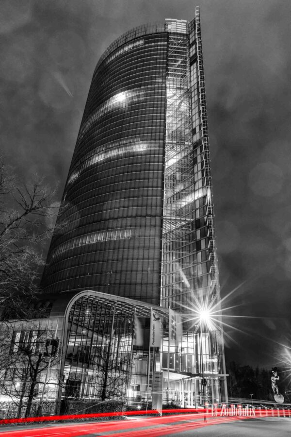 Nachtaufnahme am Post Turm in Bonn im Hochformat mit Blick auf die DHL Hauptzentrale bei Nacht. Zu sehen sind die Light Trails des vorbeiziehenden Verkehrs