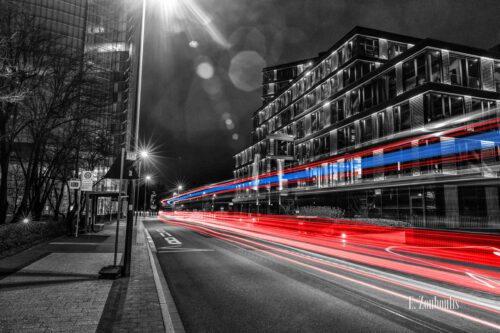 Nachtaufnahme am Post Turm in Bonn mit Blick auf die DHL Hauptzentrale und das infas Instituts bei Nacht. Zu sehen sind die blauen und roten Light Trails des vorbeiziehenden Verkehrs vor der gleichnamigen Bushaltestelle an der Kurt-Schumacher-Straße.