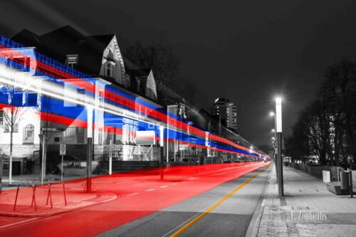 Nachtaufnahme am Post Turm in Bonn mit Blick auf die Kurt-Schumacher-Straße bei Nacht. Zu sehen sind die blauen und roten Light Trails des vorbeiziehenden Verkehrs.